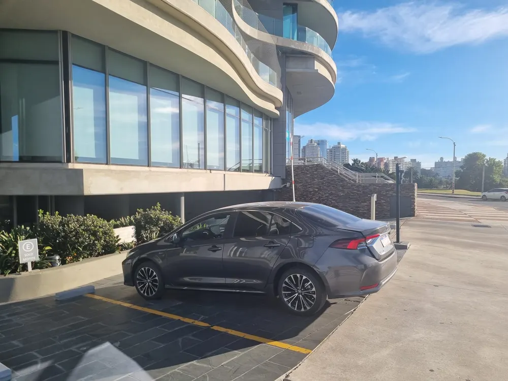 Toyota Corolla Hybrid de Acremises frente a un edificio costero